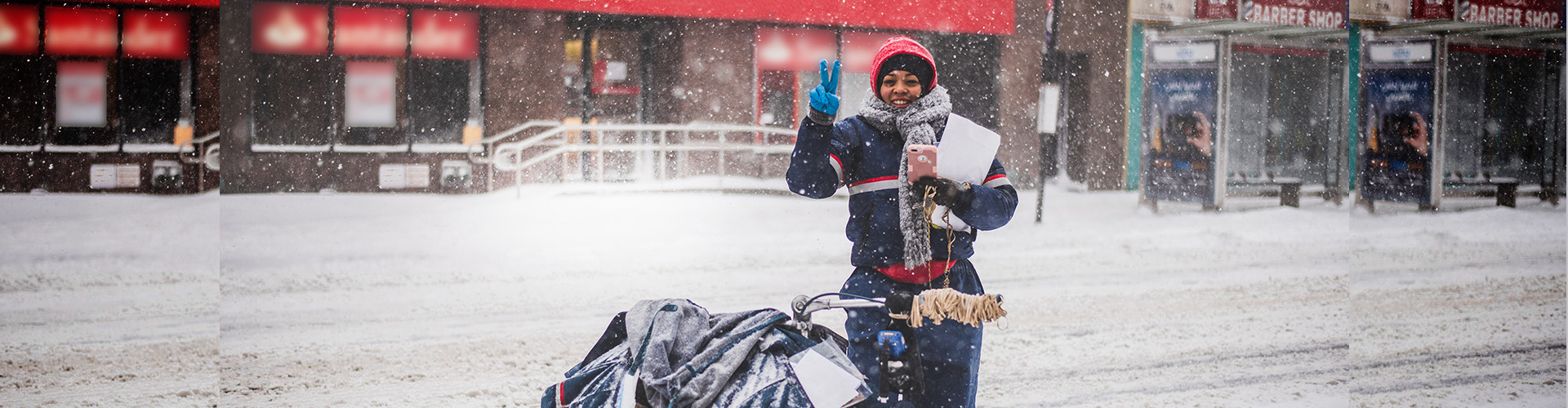 USPS worker carrying mail in the snow