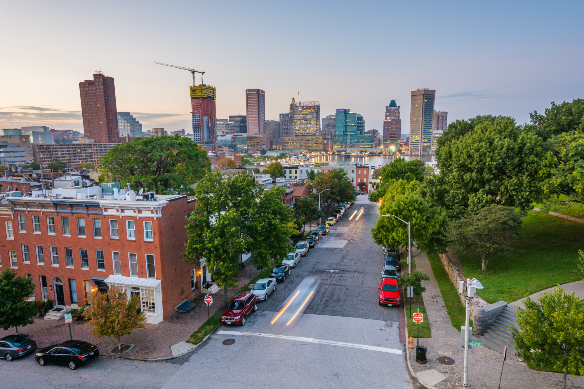 City of Baltimore with green trees and brick buildings and city streets with cars
