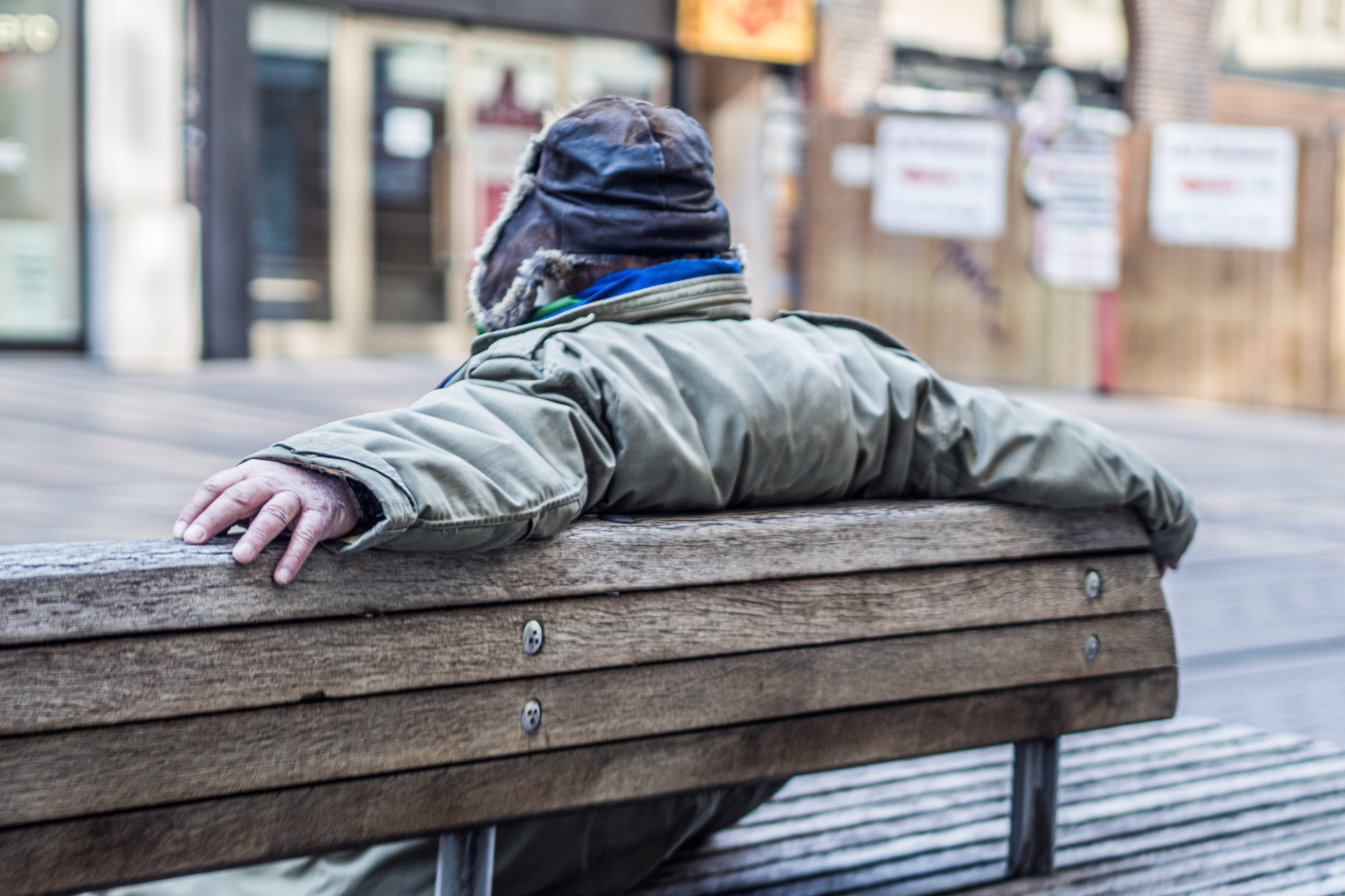 homeless person sitting on park bench