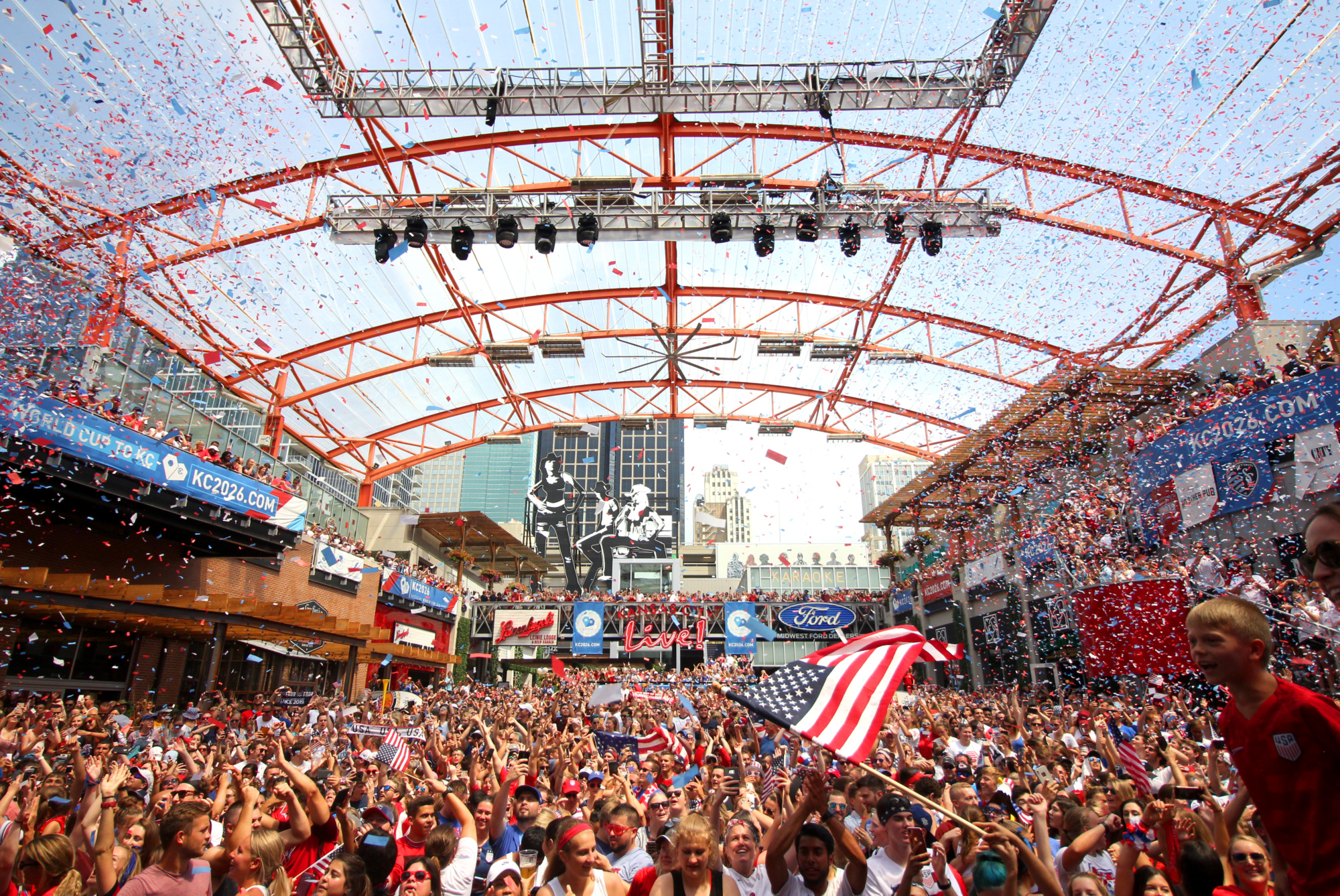 people celebrating in the city with confetti and flags